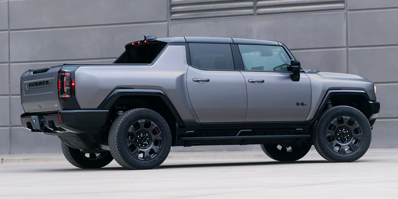 A gray Hummer EV truck parked against a neutral wall.

